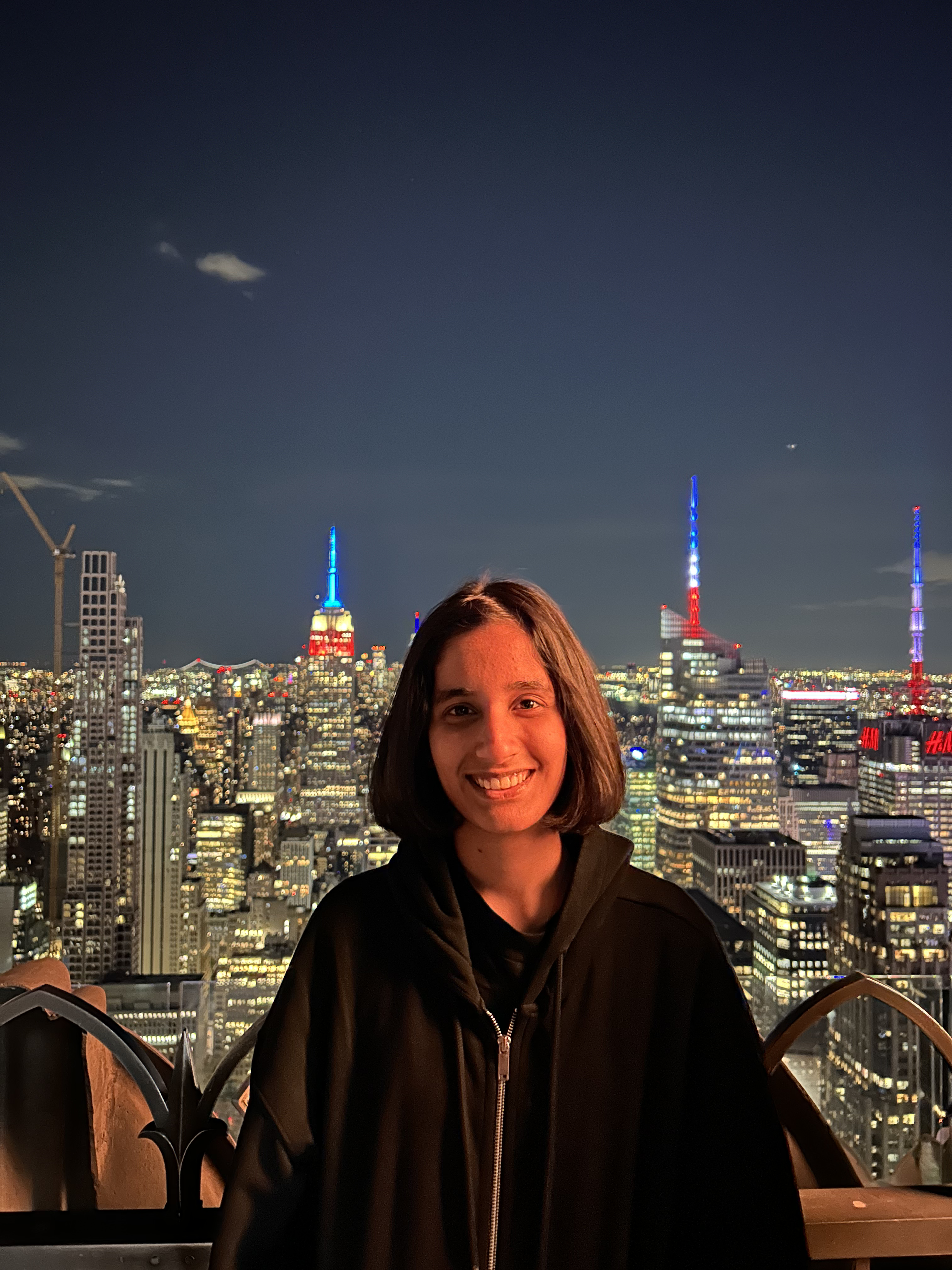 Portrait of a man with brown hair and glasses on a flat gray background.